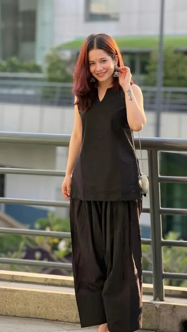 A woman wearing a black sleeveless Farshi Suit and matching wide-leg Farsi Salwar