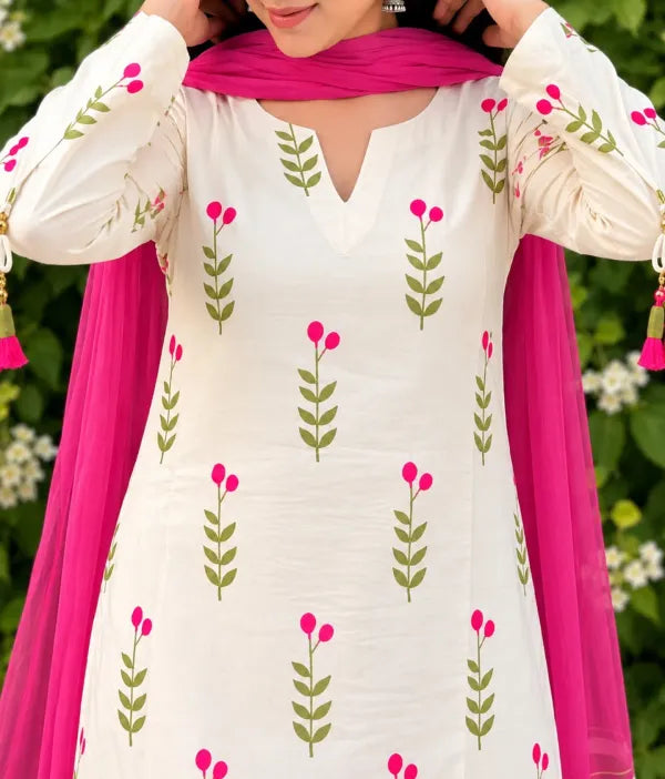 A woman wearing a Farshi suit salwar white long-sleeve kurta with green leaf and pink flower prints, paired with a bright pink dupatta, cotton set suit salwar