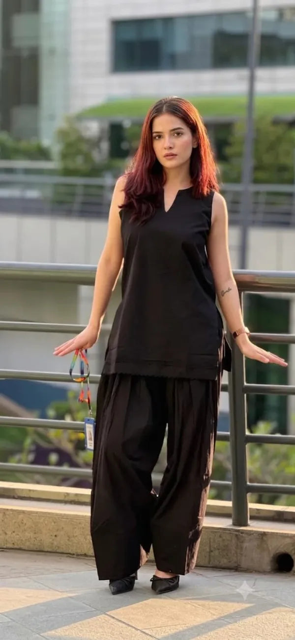 A woman wearing a black sleeveless Farshi kurta and wide-leg Salwar.