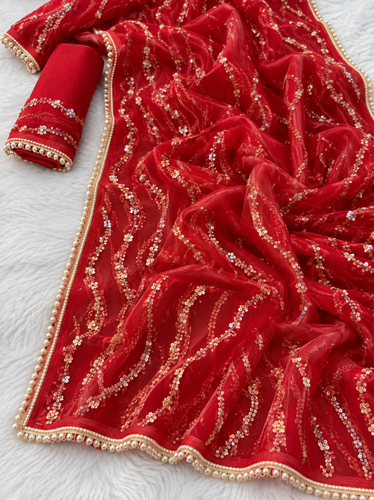 A red embroidered fabric garment or drape with metallic gold sequin patterns and a decorative gold-and-white beaded border, shown laid out on a white textured surface.