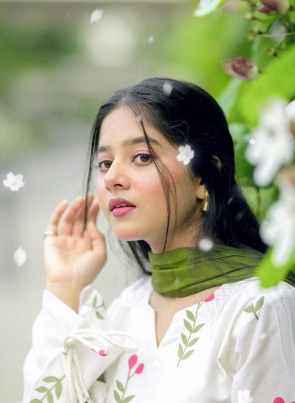 A woman in a white embroidered Farshi suit with a green Chuni