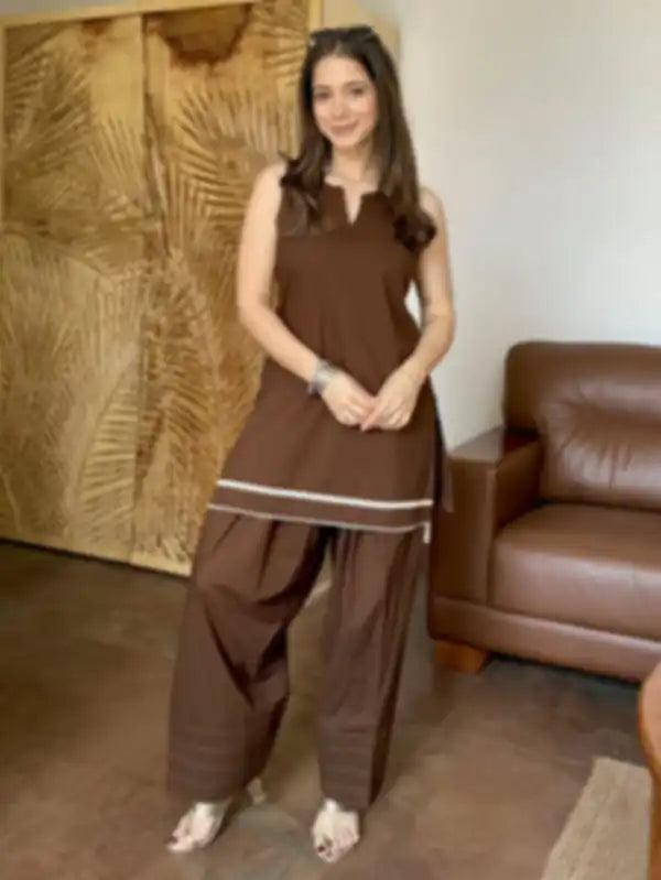 A woman modeling a brown Farshi sleeveless kurta and wide-leg Salwar set with white stripe accents, fabric Cotton
