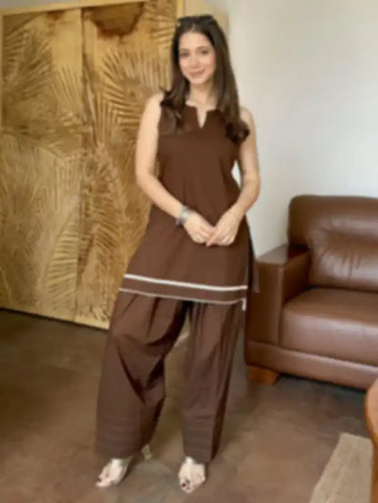 A woman modeling a brown Farshi sleeveless kurta and wide-leg Salwar set with white stripe accents, fabric Cotton

