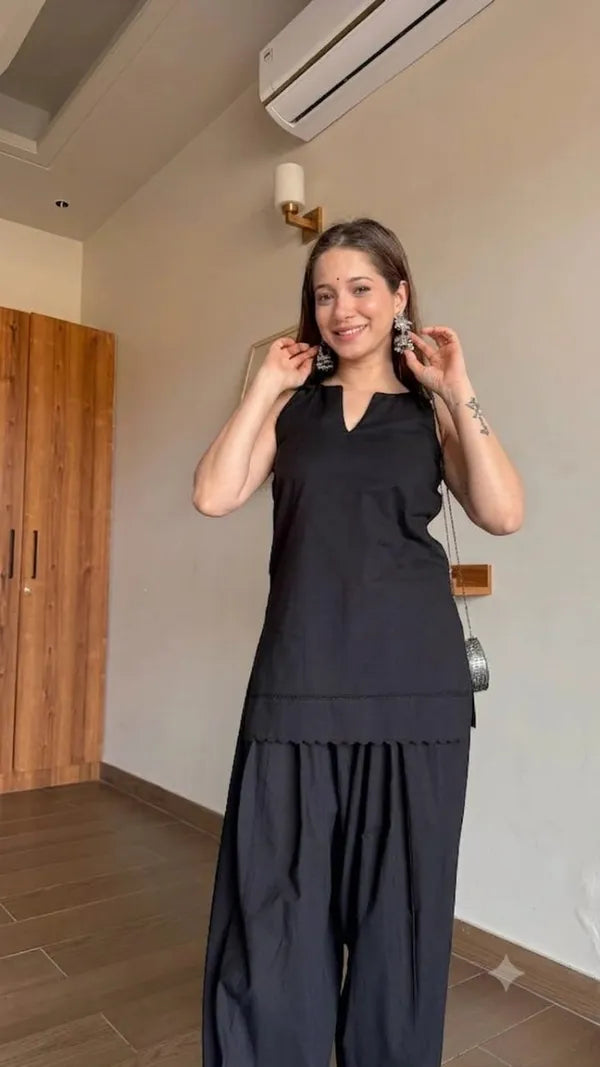 A woman modeling a black sleeveless Farshi Suit and matching wide-leg Salwar