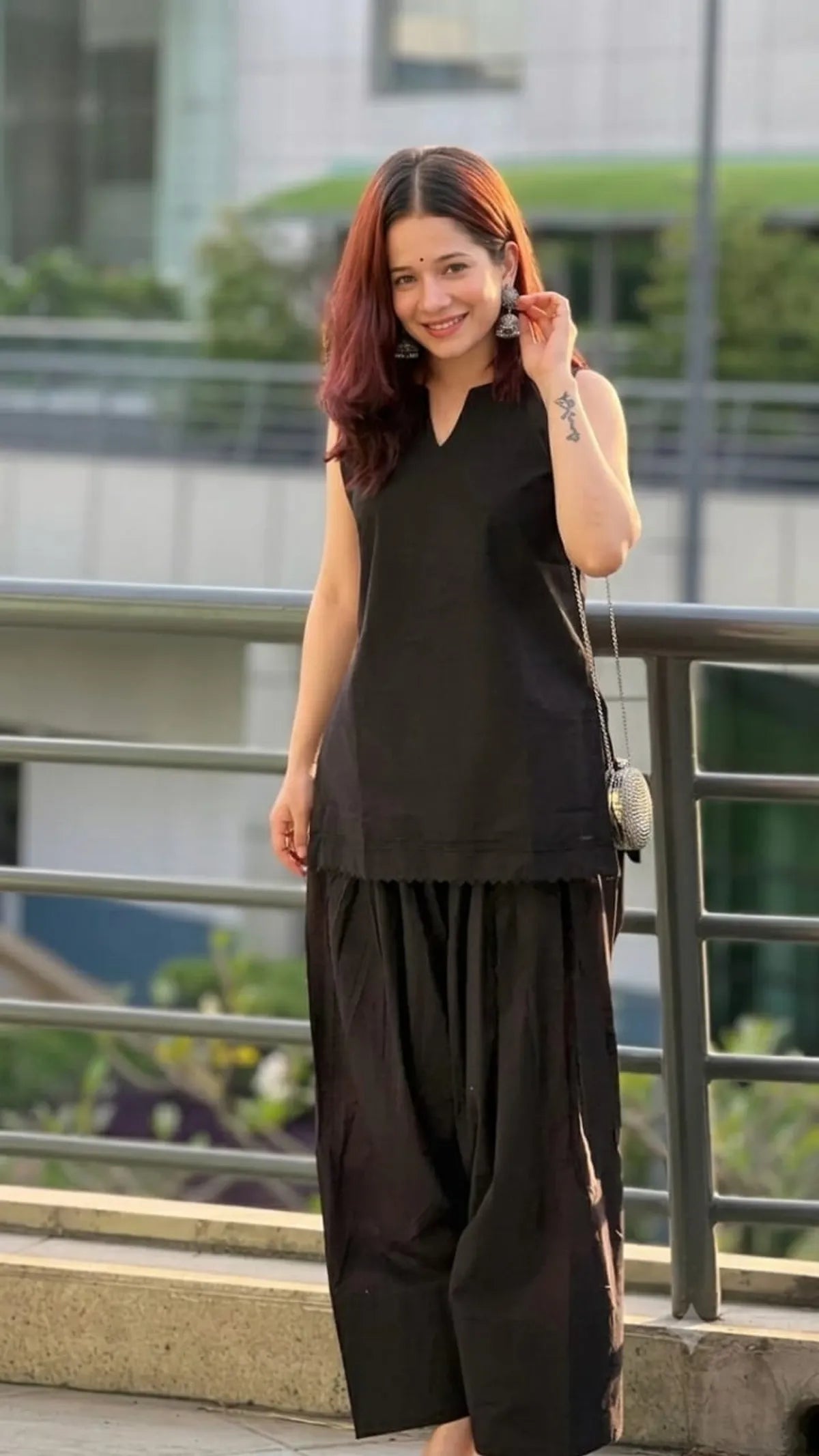 A woman wearing a black sleeveless Farshi Suit and matching wide-leg Farshi Salwar
